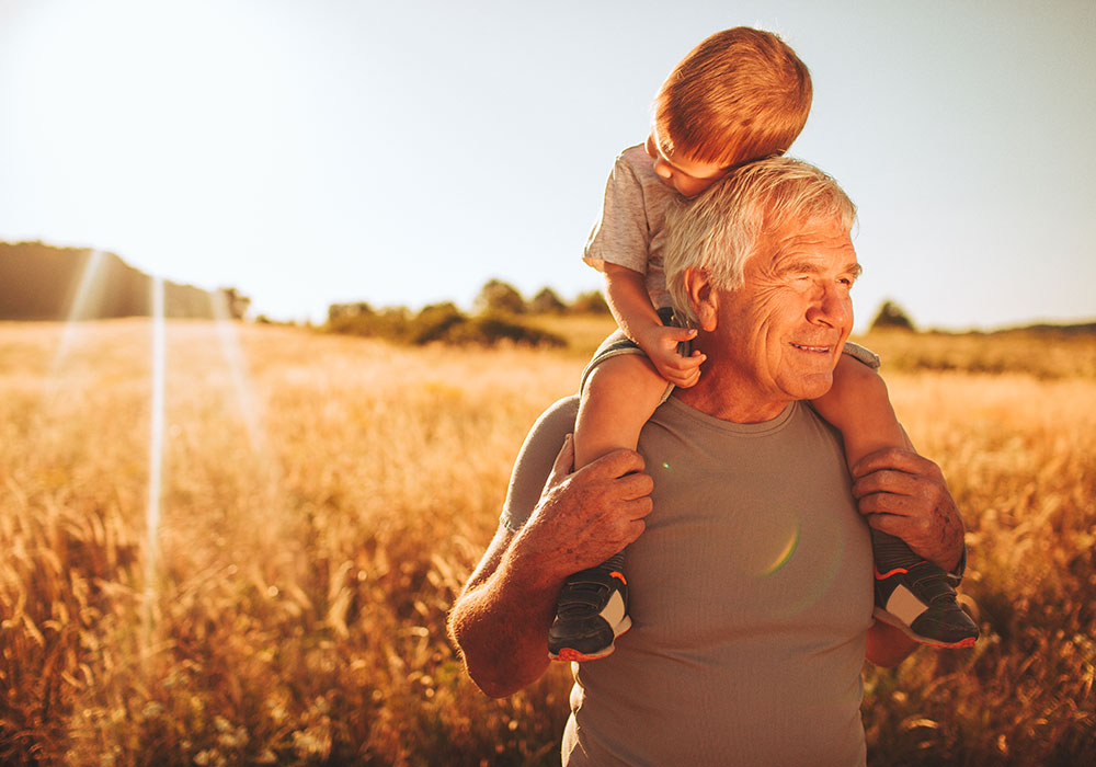 grandfather holding grandson on shoulders